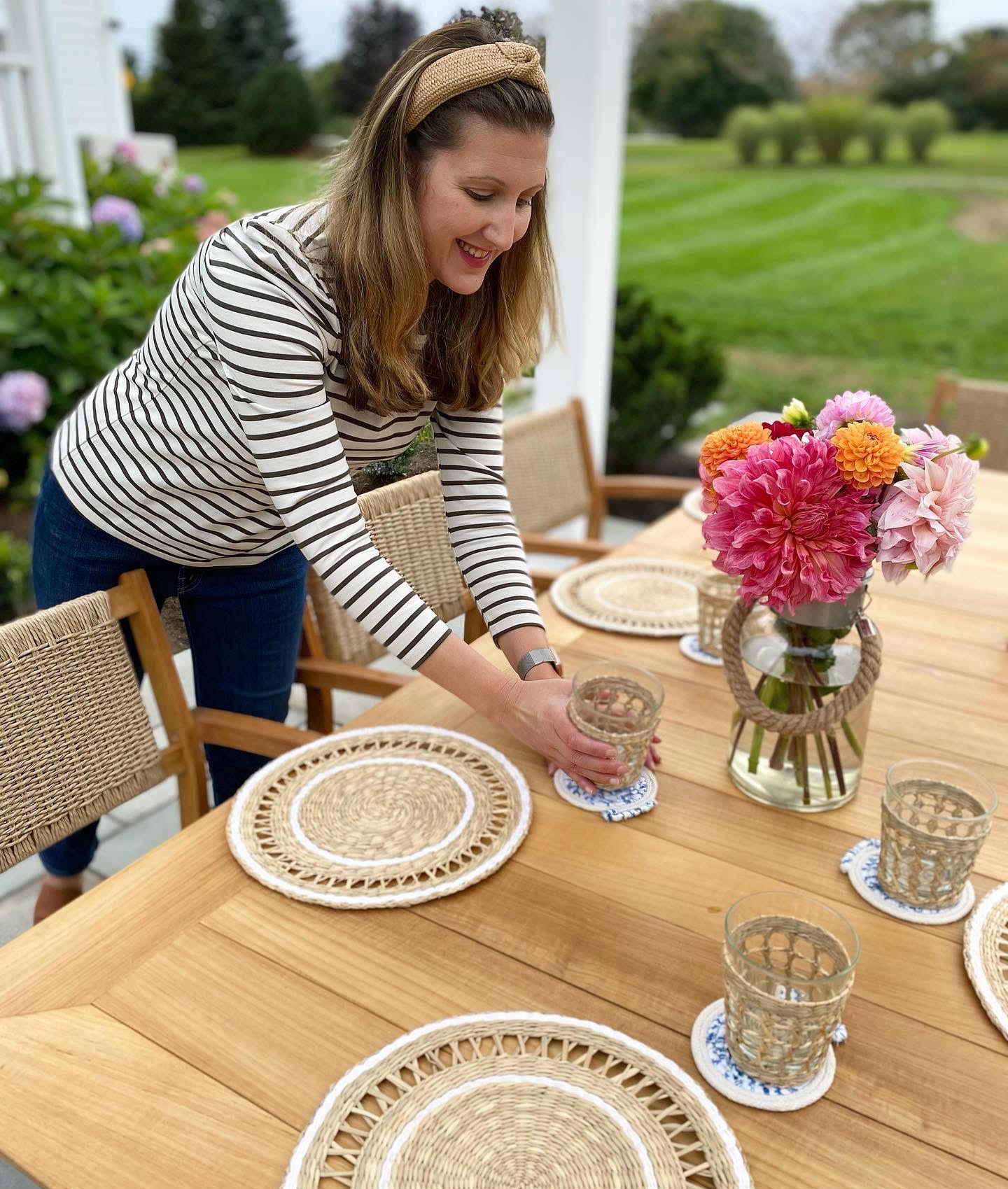 Roula Rallis setting a Horizon teak table with hand woven placemats