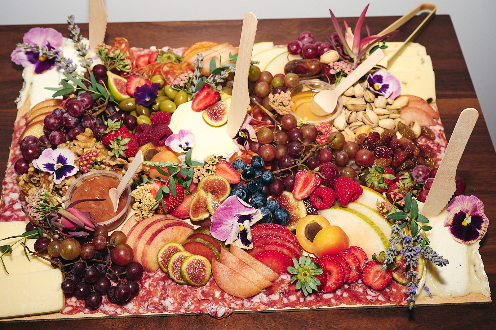 Assorted fruits, cheeses, and dips arranged on a tray