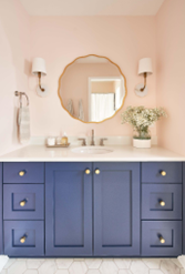 Blue cabinet with white sink and round mirror