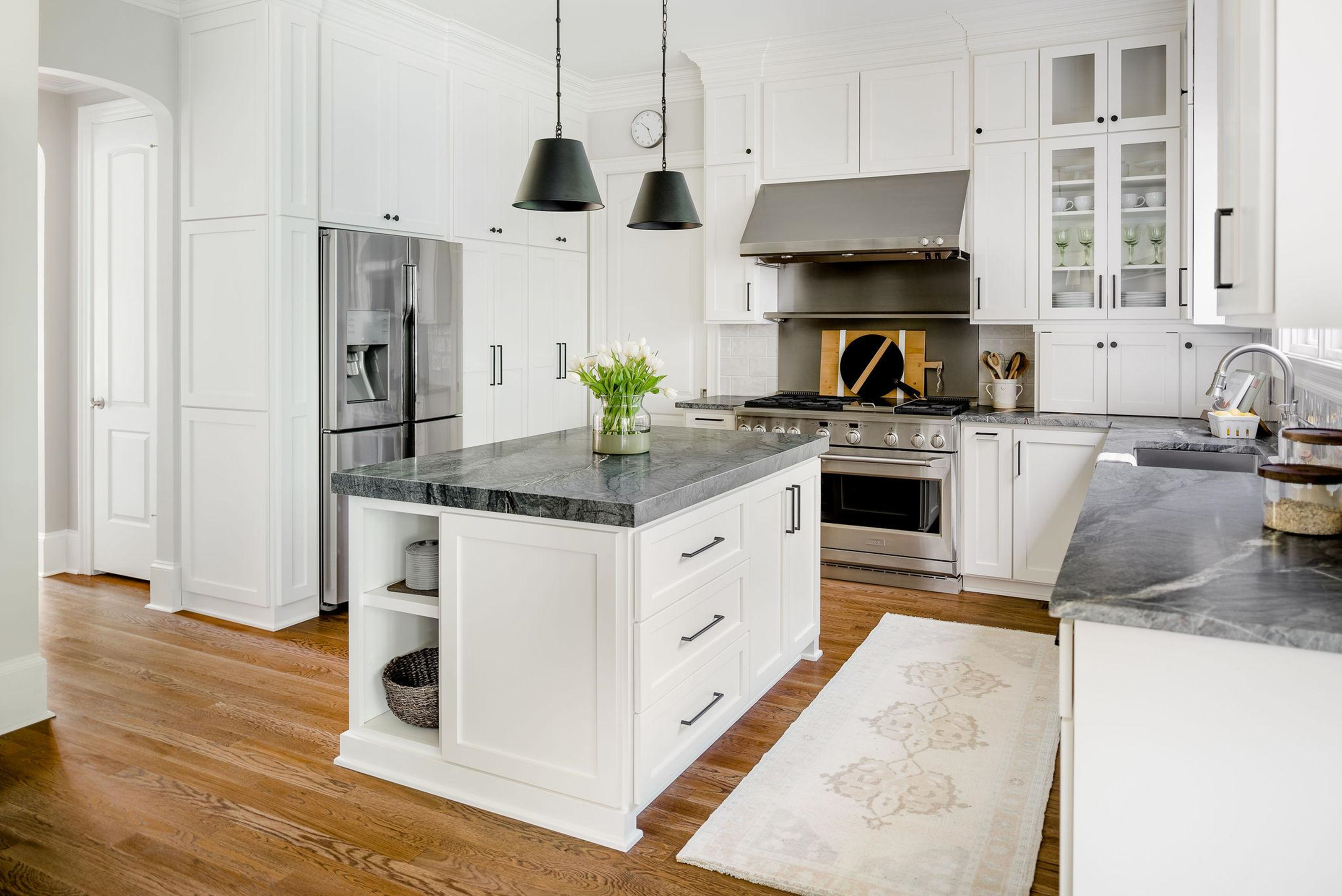 White kitchen with grey marble countertops and stainless steel appliances