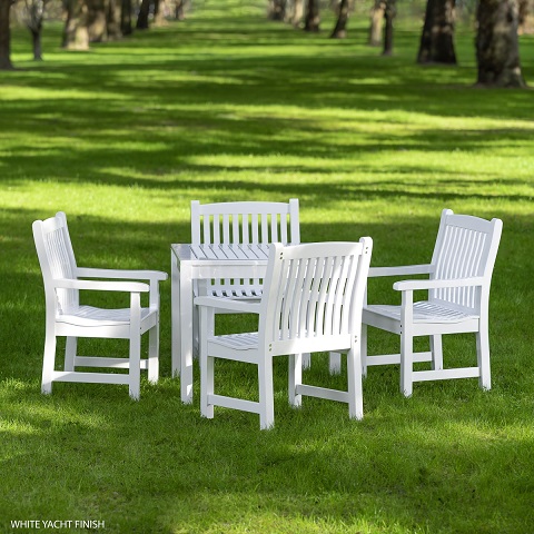 An image of Veranda 5 piece square Dining Set in Satin White finish on grass lawn with trees in background.