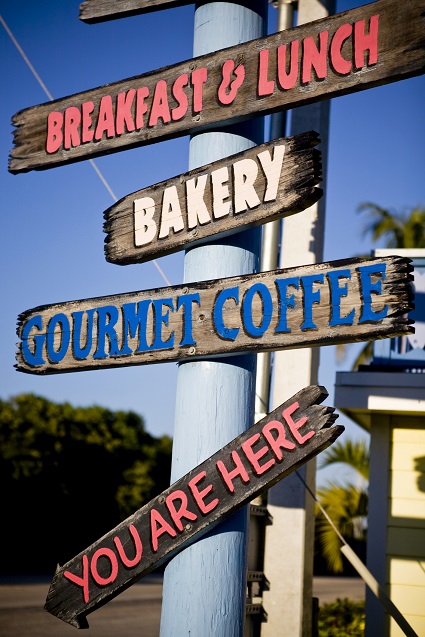 An image of a breakfast sign with tropical shrubs and blue sky  in Key Largo, Florida.