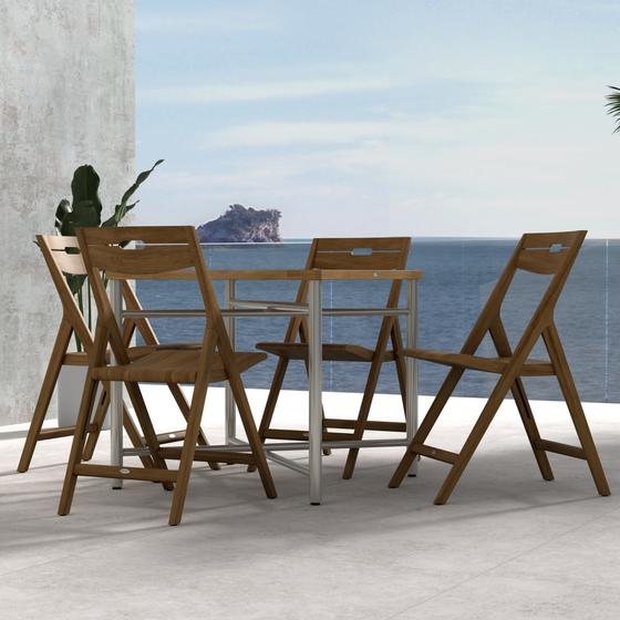 70450 Surf Odyssey Folding Dining Set of Odyssey Bistro Table and 4 Surf Side Chairs in side view on a stone patio with the ocean and blue sky in the background
