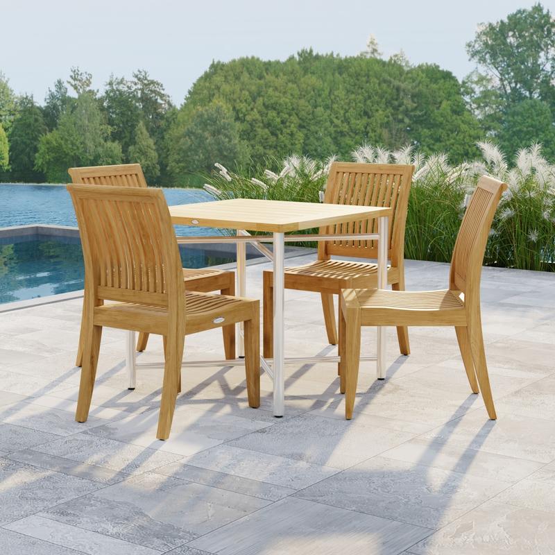 alt="70595 Odyssey Laguna Dining Set showing Odyssey Teak and 316L Stainless Steel 32 inch Square Dining Table and 4 Laguna Side Chairs on patio next to a pool with plants and waterview in background"