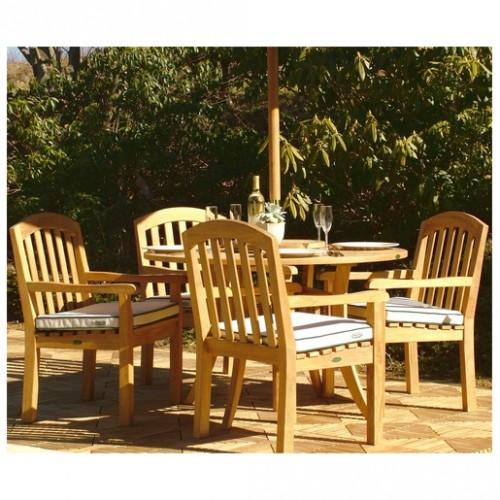 70003 Curved Back teak 5 piece Dining Set of teak 48 inch round dining table and 4 teak curved back dining chairs with optional seat cushions side view on teak tile floor and trees in back