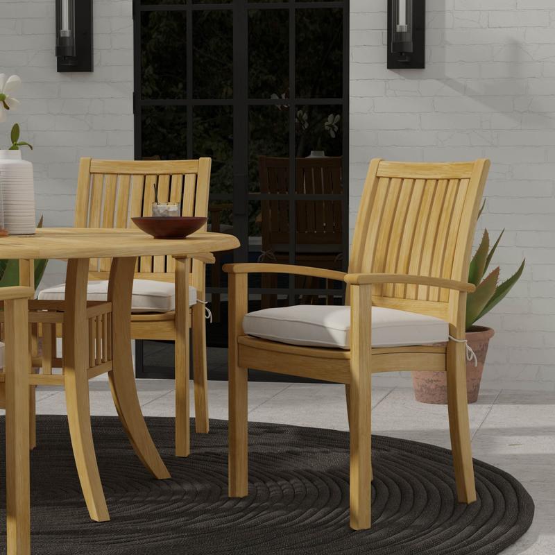 alt="12196 Sussex teak stacking armchair with optional seat cushion angled on outdoor patio with french door and 2 candle scones and potted plant in background "