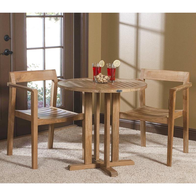 alt="70250 Horizon 3 piece teak Bistro Set of 2 dining armchairs and 30 inch round dining table with 2 ice tea glasses and bowl of snacks on table indoors on carpet with french door in background"