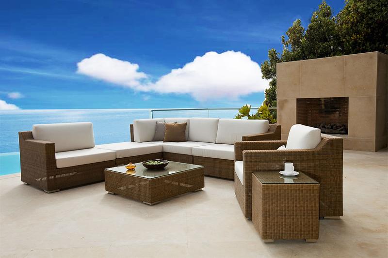 alt="31006 malaga sofa sectional set on concrete patio with cup and saucer and bowls on tables with fireplace and trees and ocean in background"