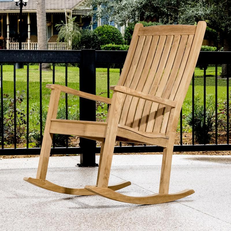alt="12223 two veranda teak rocking chair front view on brick porch with railing plants and trees in background"
