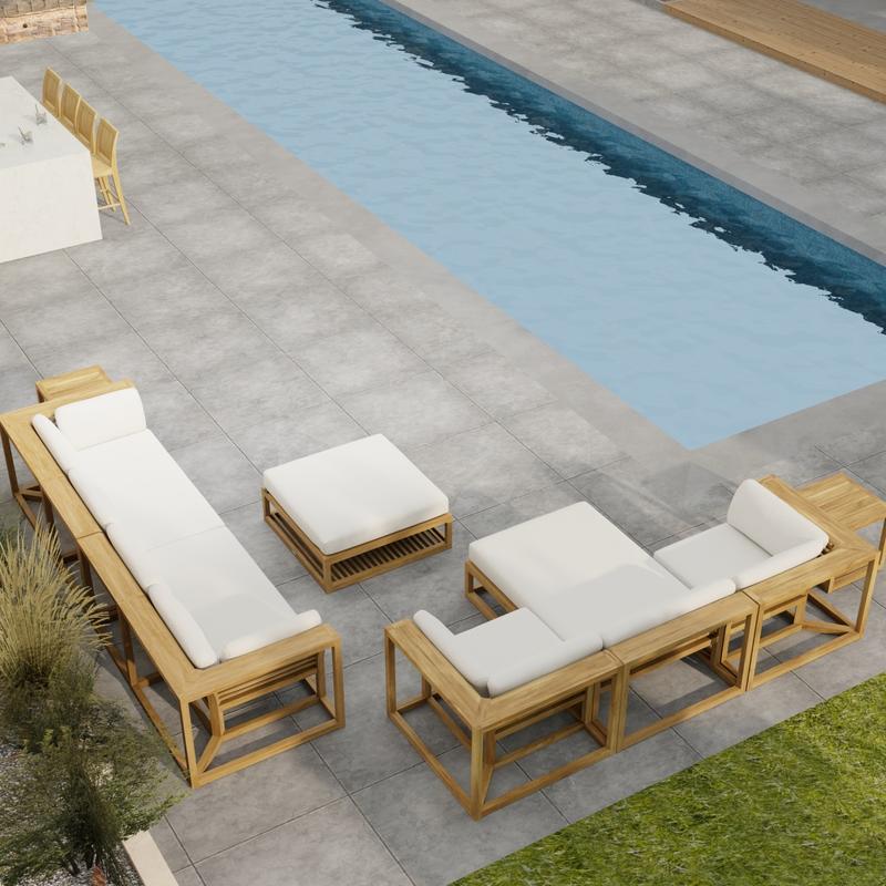 alt="70233 Maya 7 pc Sectional Furniture Set in angled aerial view on a patio next to a pool with landscape plants and a privacy wall and door in the background"