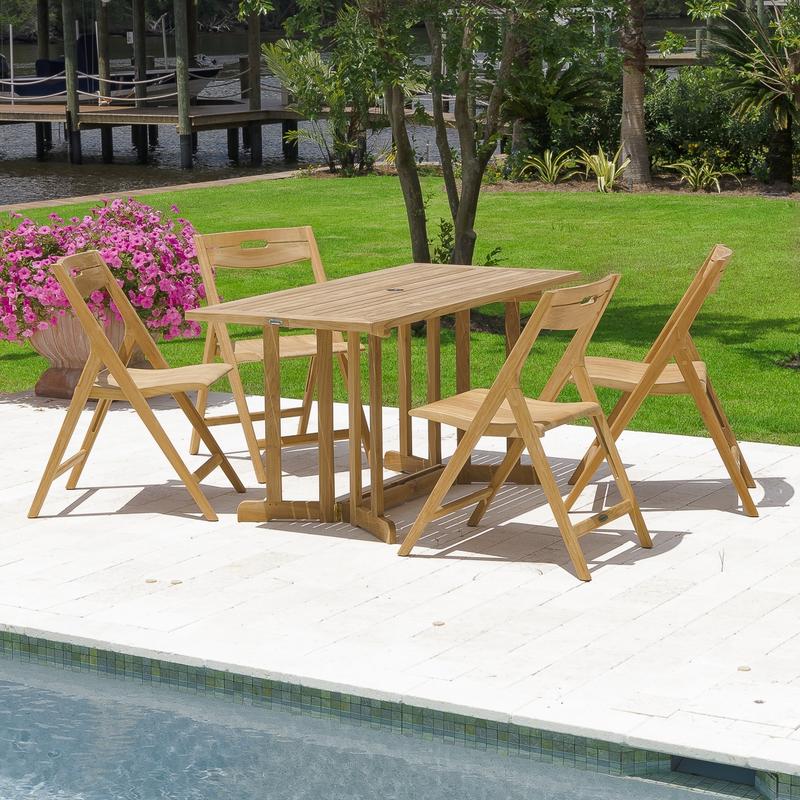 alt="70475 Surf Nevis 5 piece teak rectangular Dining Set on concrete pool patio next to potted flowering plant with grass lawn trees and shrubs a dock and lake in background"