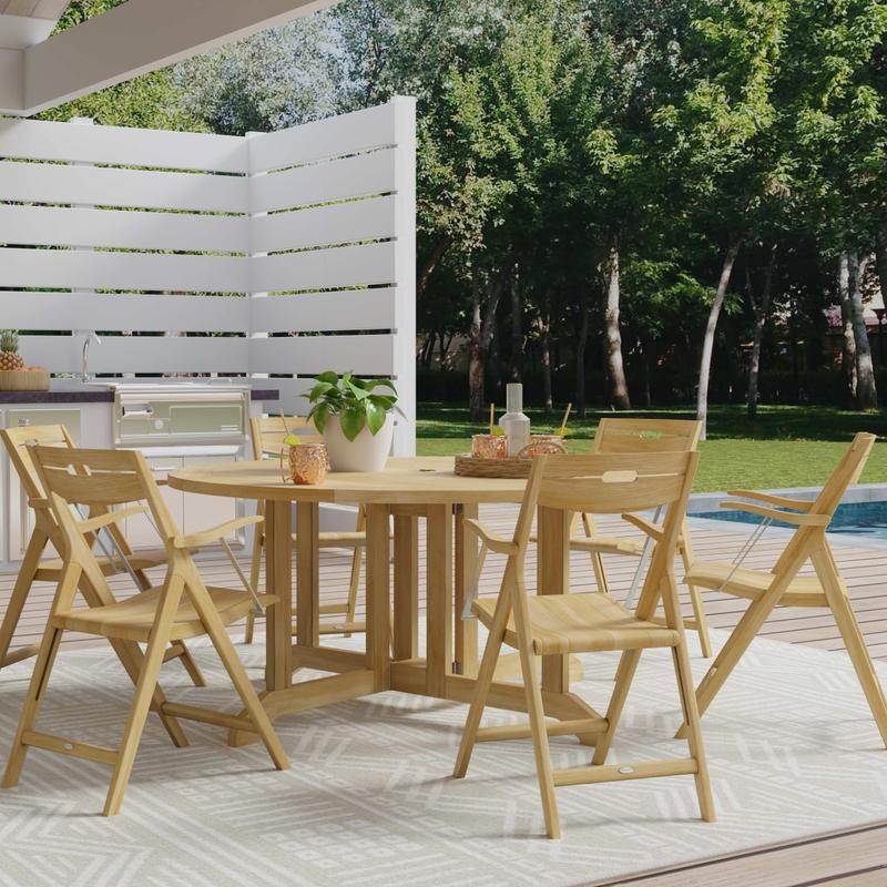 alt="70846 Barbuda Surf 7 piece 60 inch diameter round folding Dining Set with tray drinks and potted plant on patio next to outdoor kitchen and privacy fence angled  view next to pool and trees"