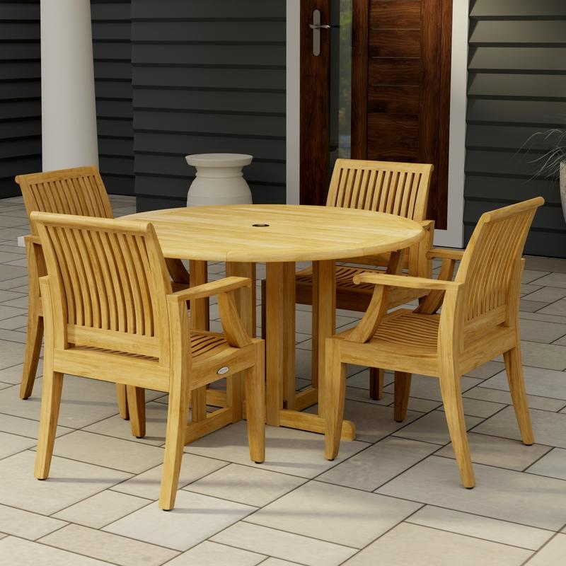 alt="70736 Barbuda Laguna Dining Set of Barbuda 4 ft Round Dining Table and 4 Laguna Arm Chairs on tiled patio angled side view with home and door in background"