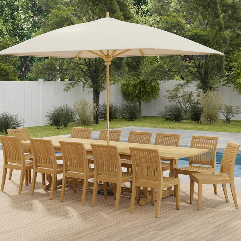 alt="70124 Grand Laguna 13 pc Teak Side Chair Set with optional opened umbrella in angled side view on a patio in front of a pool with plants and fence in background"