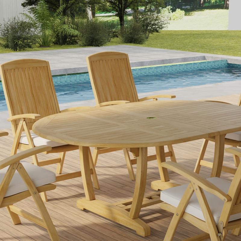 alt="70367 Martinique Barbuda Recliner Dining Set showing partial closeup angled view on patio next to a pool with landscaping trees and privacy fence in the background   "
