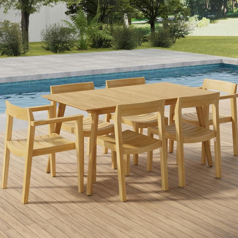 alt="70525 Surf Horizon 7 pc Dining Set of a Surf Teak 60 inch Rectangular Table angled aerial view on patio in front of a pool with grass and landscaping plants and trees and white fence in the background"