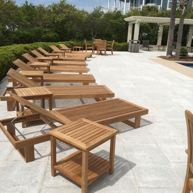alt="14107 Veranda Teak End Tables with horizon loungers on concrete patio with trees and house in background"