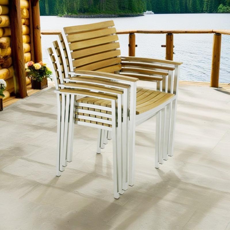 alt="22007ST Vogue Dining Chair in side angled view stacked 4 high on outdoor deck with a lakeview in background"