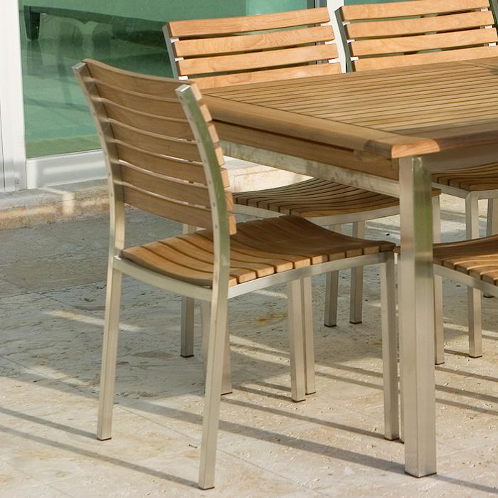 alt="21007 Vogue Side Chair right side at end of vogue extension table on concrete patio"
