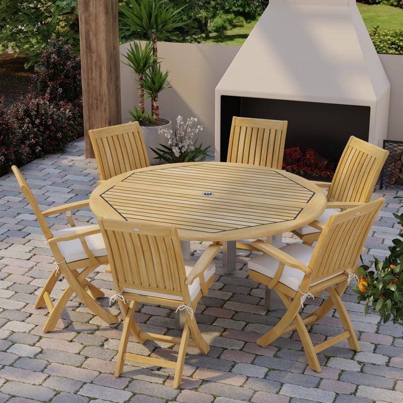 alt="70357 Vogue Barbuda 7 pc Dining Set angled aerial top view on brick paver patio in front of an outdoor fireplace and landscape plants in background"