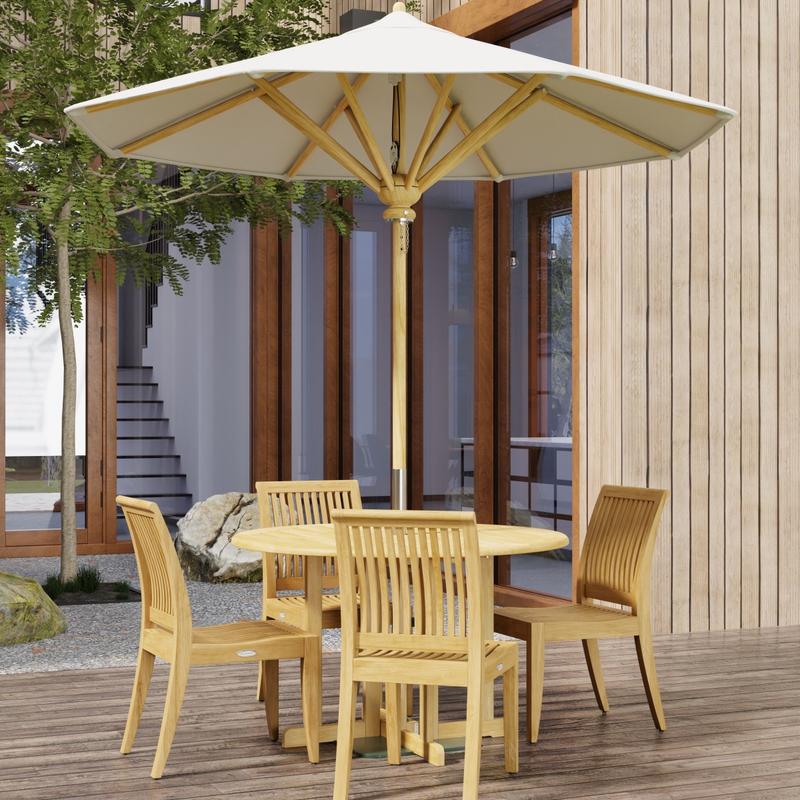 alt="70732 Barbuda Laguna 5 pc Teak Dining Set in angled side view with optional opened umbrella on patio with trees and french doors and windows of house in the background"