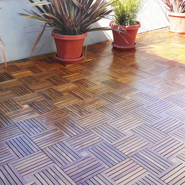 alt="70406 Parquet 10 pack Teak 18 inch Deck Tiles on terrace with 3 potted plants against balcony rail in background"