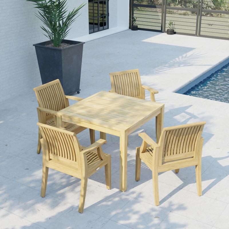 alt="70555 Laguna 5 pc Square Dining Set of Bistro 36 inch Square Teak Dining Table and 4 Laguna Dining Armchairs in angled aerial view on patio with house pool and fence in the back"