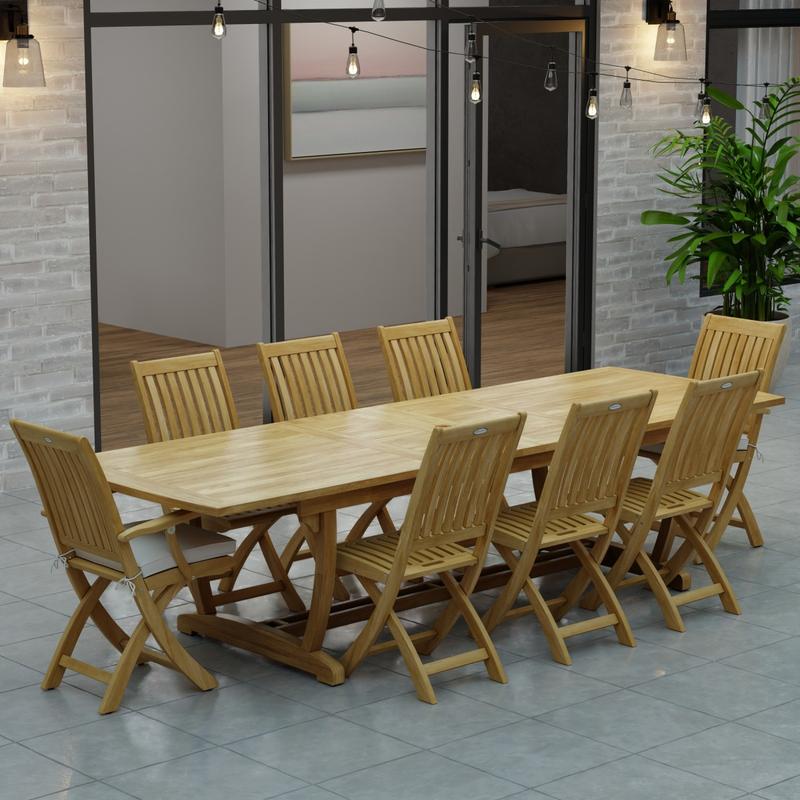 alt="70794 Veranda Barbuda Teak 9 pc Dining Set of Grand Veranda Dining Table and 2 Barbuda Armchairs and 6 Side Chairs on a patio with patio lights and glass doors of house in background"