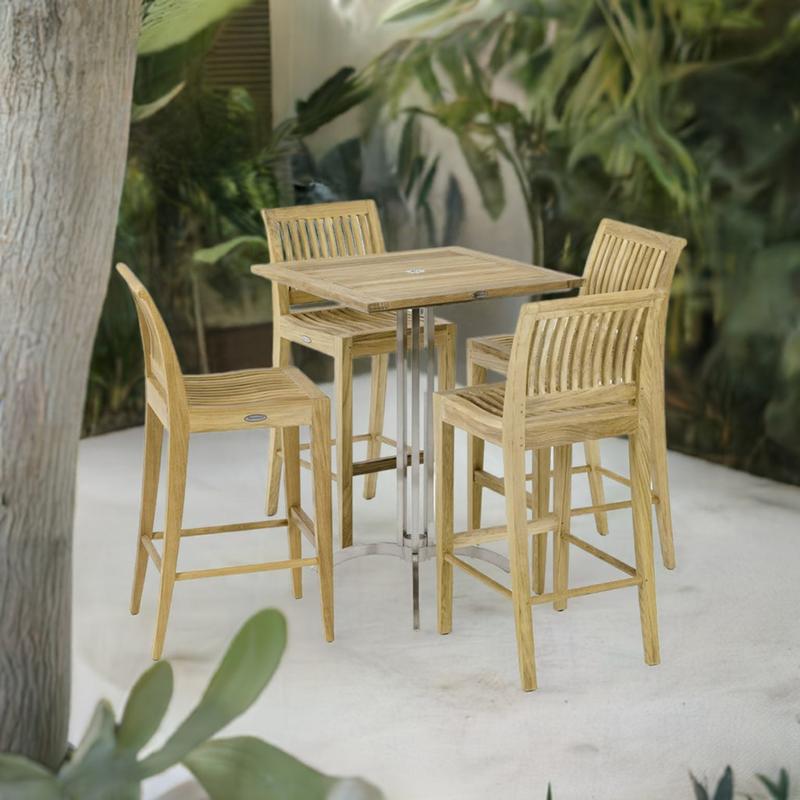 alt="70638 Laguna Vogue Teak Square Bar Set of 36 inch square teak and stainless steel bar table and 4 teak side barstools angled on patio surrounded by landscaping plants and trees"
