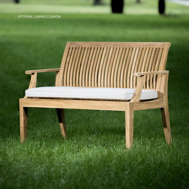 alt="13810 Laguna 4 foot Teak Bench with optional seat cushion side angled on grass field with trees in background"