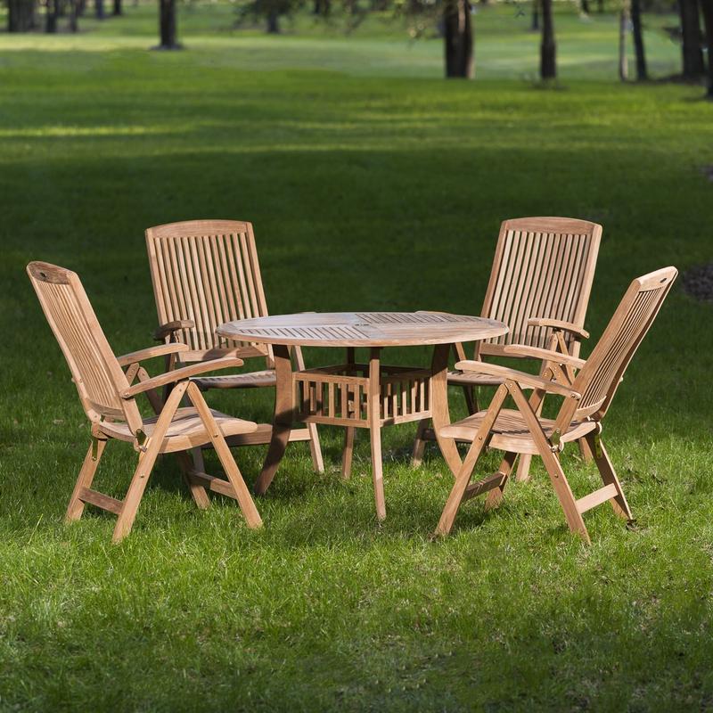 alt="70045 Hyatt Recliner 5 piece teak Dining Set of 4 teak reclining armchairs and a round 48 inch diameter dining table on grass field with trees in background "