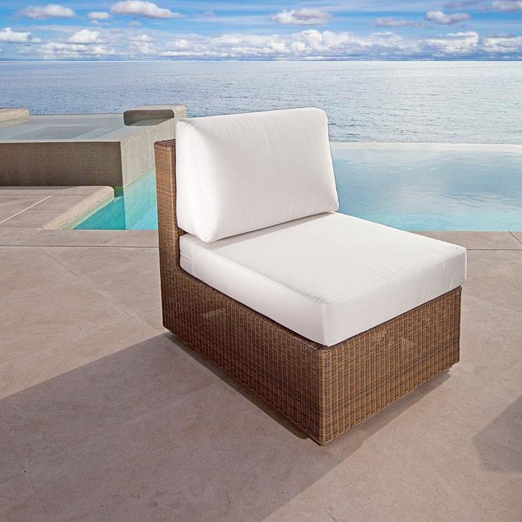 alt="70240 malaga wicker slipper lounge chair with cushions angled on patio with pool ocean and blue sky in background"