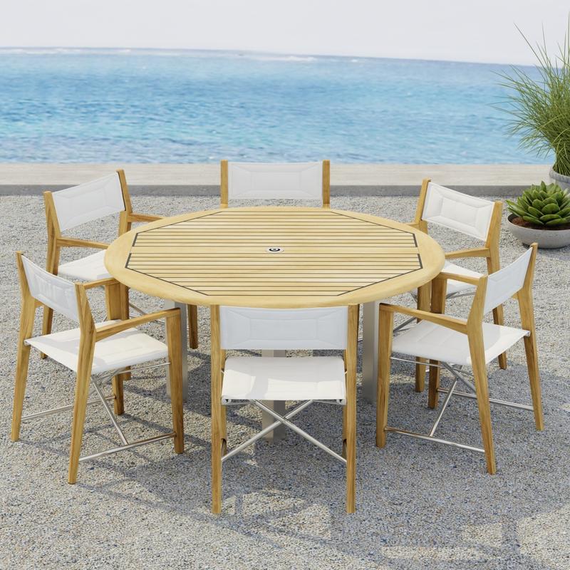 alt="70359  Vogue Odyssey 7 pc Dining Set showing Vogue 5 ft Round Table and 6 Odyssey Chairs on terrace angled side view with 2 potted plants and ocean in the background"