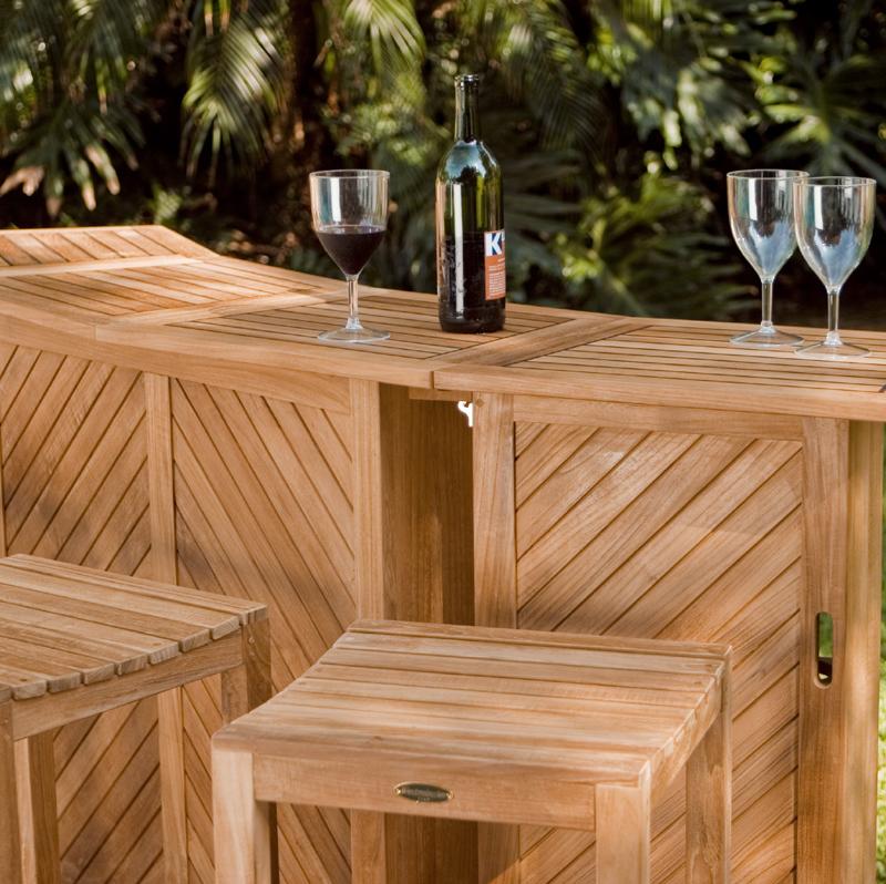 alt="12110 somerset backless barstool with somerset teak bar with a bottle of wine and three wine glasses closeup with trees in background"