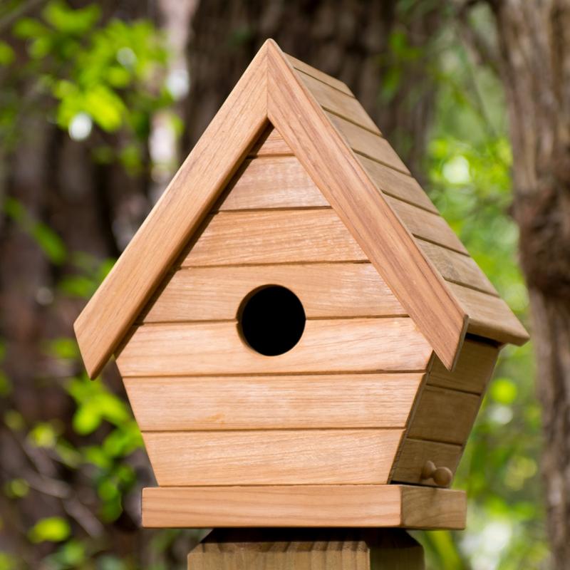 alt="19003 teak bird house on fence post front view with trees in background"