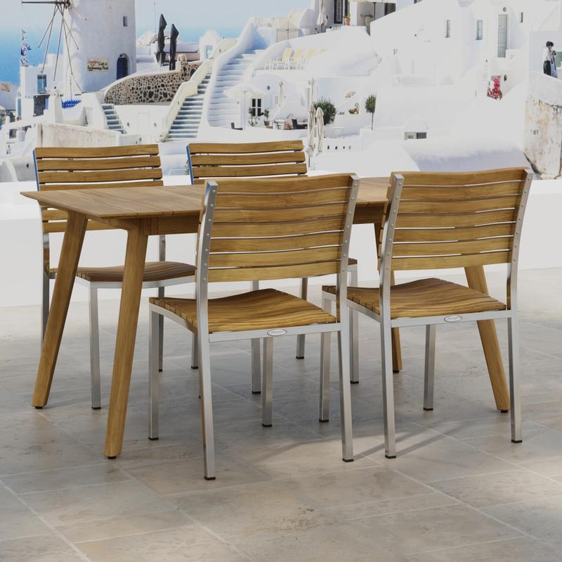 alt="70552 Vogue Surf 5 pc Dining Set of Surf Table and 4 Vogue Side Chairs on an outdoor terrace in angled side view with homes and ocean in background"