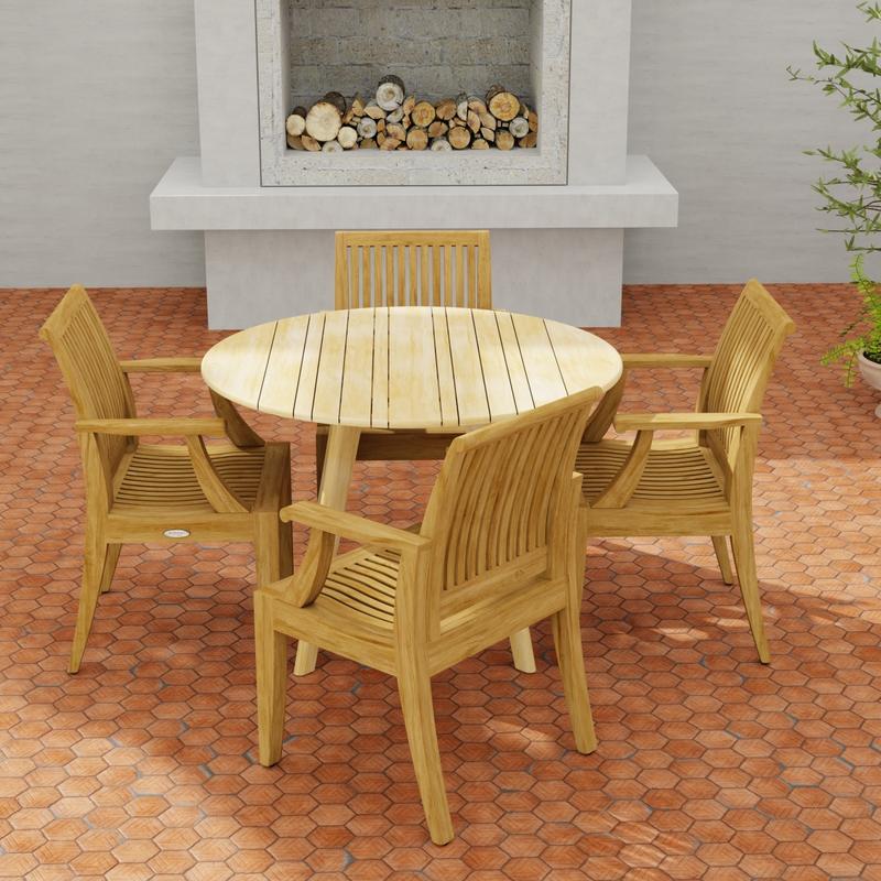 alt="70544 Laguna & Surf 5 pc Dining Set of Surf Folding 42 inch Round Table and 4 Laguna Dining Armchairs in angled side view on a patio with outdoor fireplace in background"
