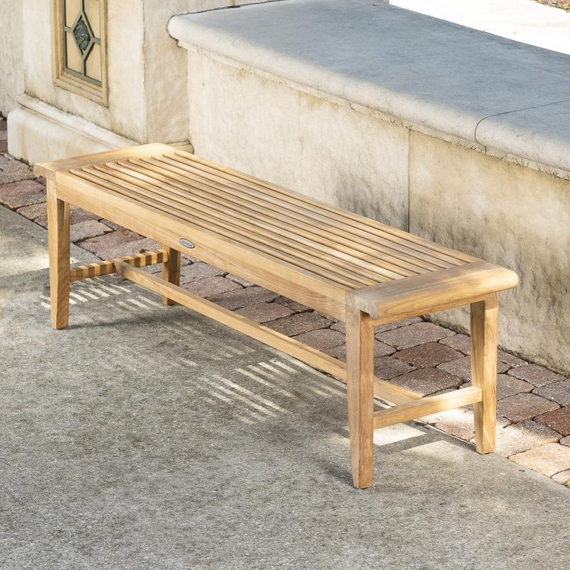 alt="13916 Laguna Teak 5 foot Backless Bench angled view on concrete stone patio with concrete low wall in background"
