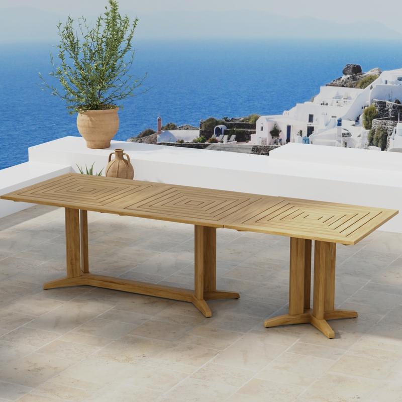 alt="70936 Pyramid Teak Table Set of Pyramid Teak Rectangular Table and Square Table next to potted plant in angled aerial view on outdoor terrace with houses and ocean in background"