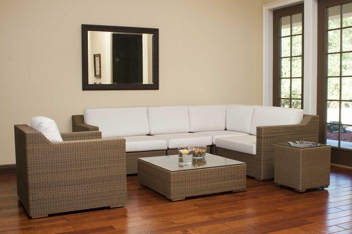 alt="31001dp Malaga synthetic wicker collection on wood floors wall mirror above sofa floating candle and bowl of snacks on table with windows overlooking yard    "