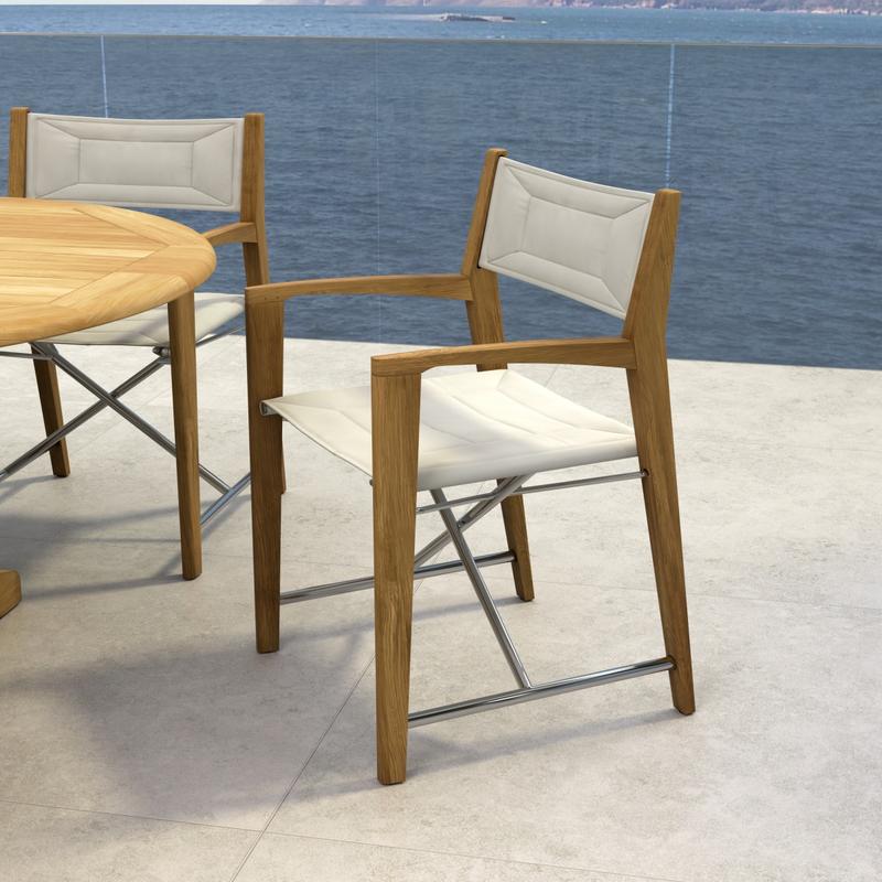 alt="70366 Oval Odyssey Chair 7 pc Dining Set on outdoor terrace showing closeup view of 2 chairs and partial view of table with ocean background "