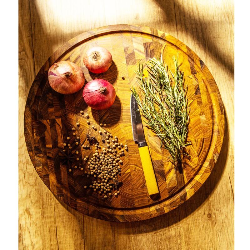 alt="19122 Butcher Block 15 inch Round Charcuterie Cutting Board with rosemary and 3 red onions and whole black pepper and a knife with yellow handle  aerial view on a counter top "