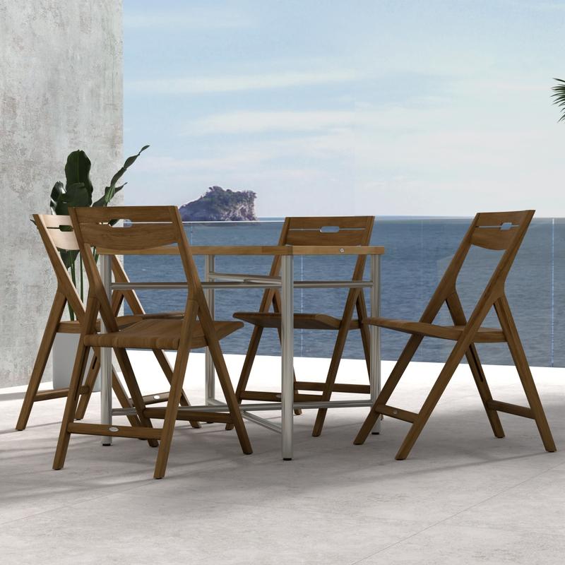 alt="70450 Surf Odyssey Folding Dining Set of Odyssey Bistro Table and 4 Surf Side Chairs in side view on a stone patio with the ocean and blue sky in the background"