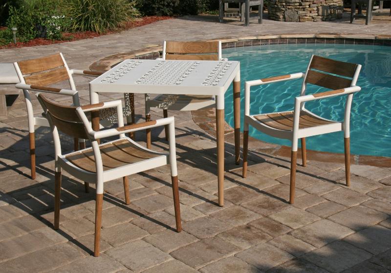 alt="4 Bloom Dining chairs around Bloom Square table on concrete square tile patio by pool"