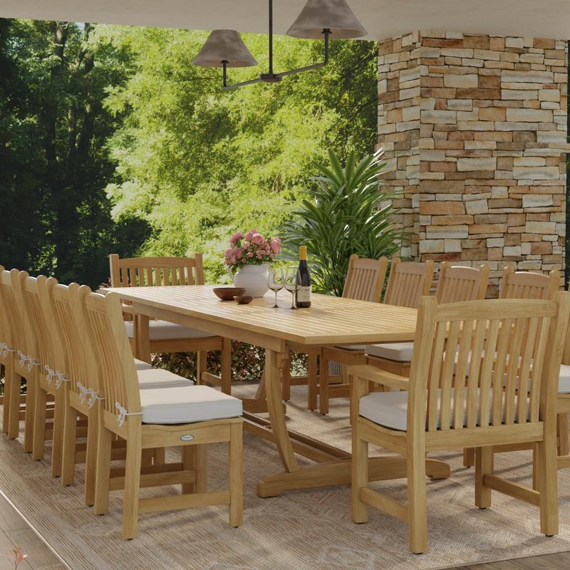 alt="70017 Grand Veranda 13 piece dining set with optional seat cushions in end view showing vase of flowers and wine glasses with bottle of wine on patio next to a stone wall "