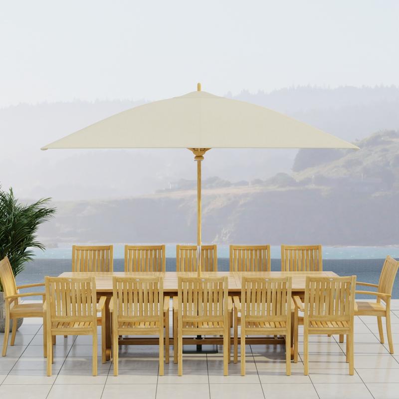 alt="70757 Sussex Veranda 13 pc Teak Dining Set with optional umbrella in side view on patio with ocean and land views in background"