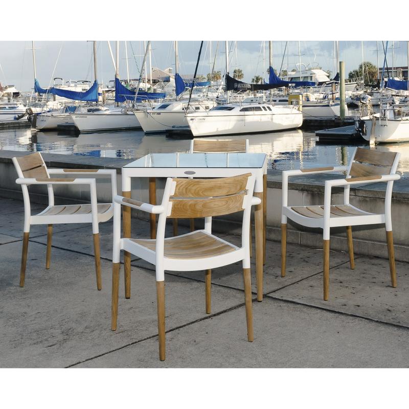 alt="70448 Bloom aluminum and teak dining table and 3 armchairs on concrete dock overlooking boat marina "