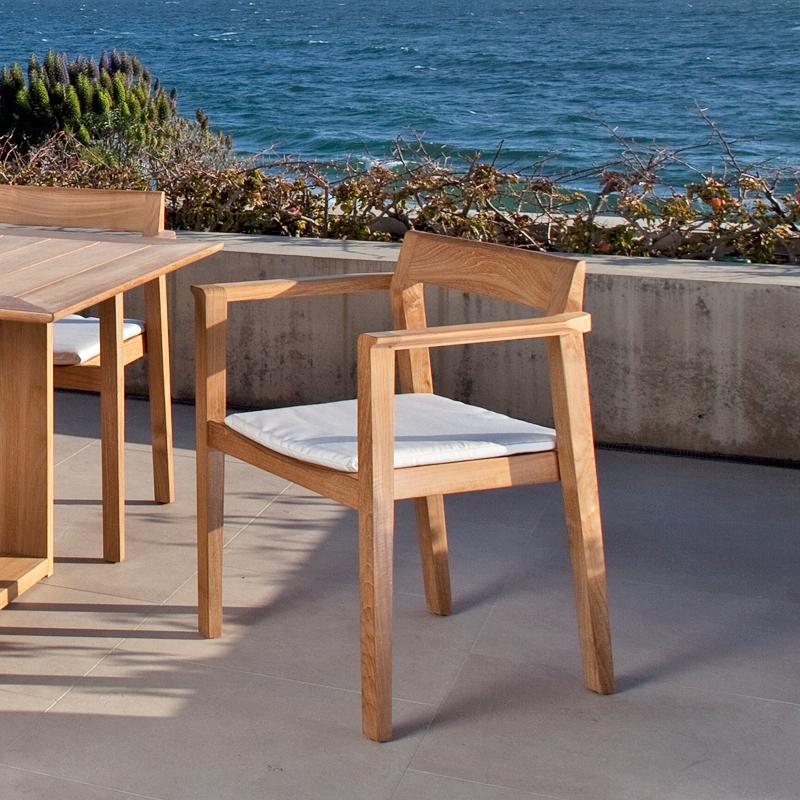 alt="12901ST Horizon Dining Chair Side angled view on concrete patio with ocean in background"