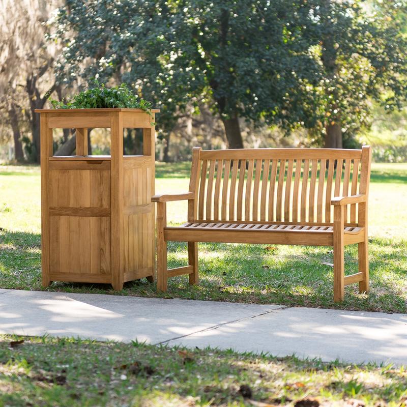 alt="13618 Veranda Teak 5 foot long Bench with teak trash receptacle left side on grass field with trees in background"