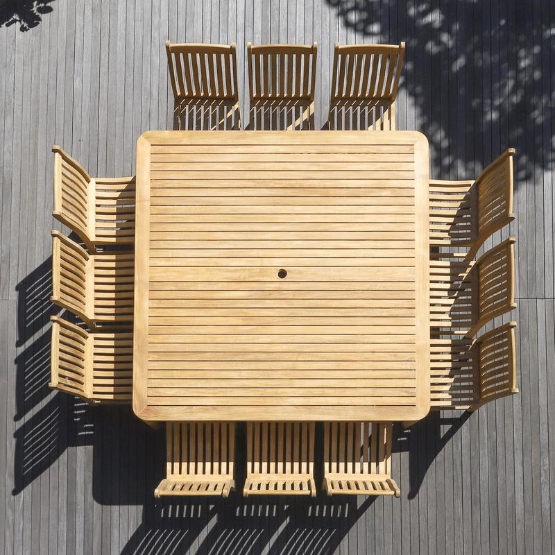 alt="70879 Veranda 13 piece teak Square Dining Set of 12 teak side chair and a teak  6 foot square dining table showing umbrella pole cutout overhead view on wood deck  "